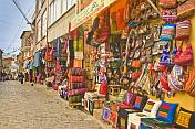 Fabrics and knitwear for sale in a street of souvenirs.