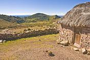 Thatched stone house and terraced farmland on the Isla del Sol in Lake Titicaca.