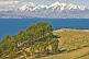Image of Trees and barren hillside on the Isla del Sol in Lake Titicaca with distant view of Andes mountains.