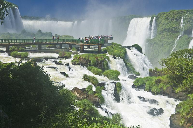 Travellers admire the waterfalls at the Iguazu Falls.