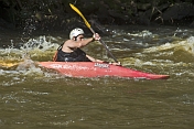 Canoeist in red Dagger kayak negotiates rapids.