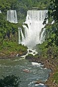 Inflatable boat approaches waterfall at the Iguazu Falls.