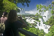 Travellers admire the waterfalls and jungle at the Iguazu Falls.