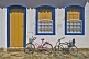 Image of Bicycles in front of colorful colonial house door and windows.