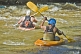 Image of Two canoeists in kayaks negotiate some turbulent water.