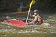 Image of Canoeist in multi-colored kayak negotiates rapids.
