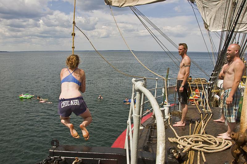 Crew of the \\'Picton Castle\\' wait their turn to swing on a rope and swim in the ocean.