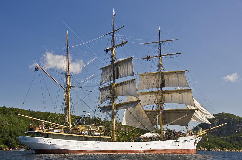 Crew climb the masts and unfurl sail as the square rigger 'Picton Castle' journeys towards the ocean.