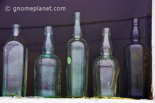 Antique drinks bottles in the window of a Curios shop.