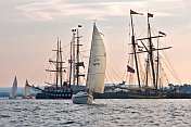 Yachts race past moored tallships in Pictou Harbour.