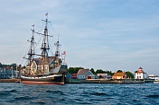 Replica pirate ship \\\\'Hector\\\\' moored to the Pictou wharf alongside colonial style buildings.