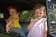 Image of Small girl with lollipop and boy in yellow shirt wait in the back seat of a Model T Ford vintage car.