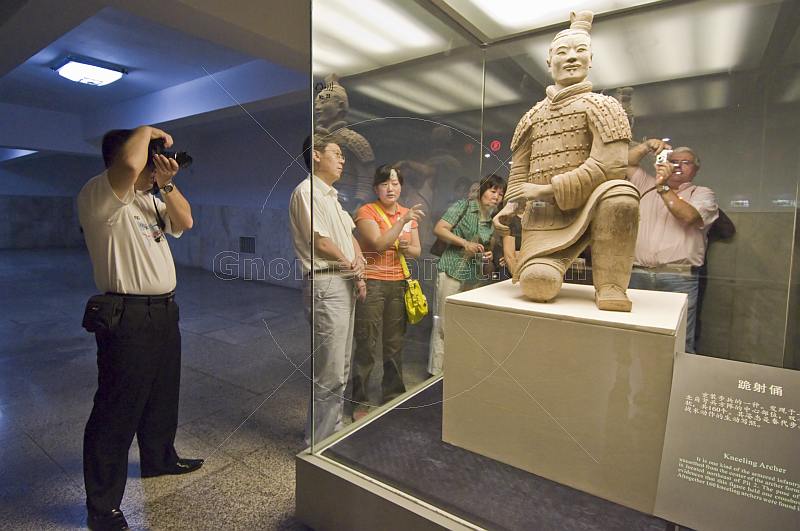 Chinese and Western visitors admire a kneeling Terracotta Archer.