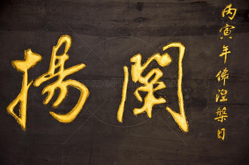 Gold Chinese characters on a black wooden background.