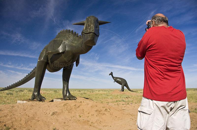 Canadian tourist in red teeshirt photographing dinosaur statues near the Monolian border.