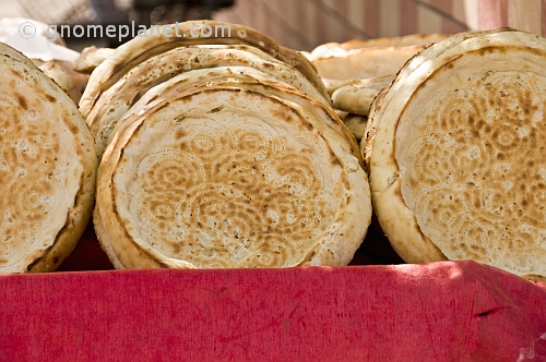 Bread stall with traditional Uighur circular bread loaves that have a flat base, used for eating meat stew.