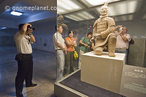 Chinese and Western visitors admire a kneeling Terracotta Archer.