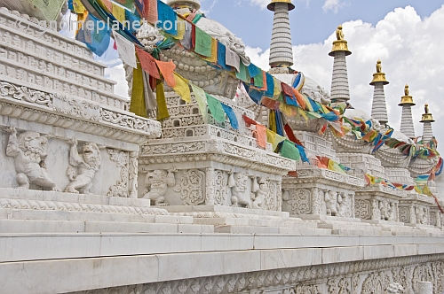 White marble Buddhist stupas draped with prayer flags, at the Dazhao Lamasery.