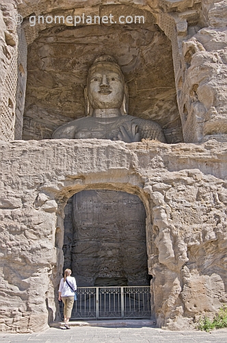Western woman looking at a giant Buddha statue at the Yungang Buddhist caves, near Datong.
