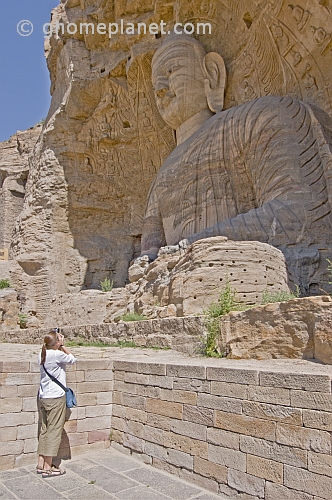Western woman photographing a giant Buddha statue at the Yungang Buddhist caves, near Datong.
