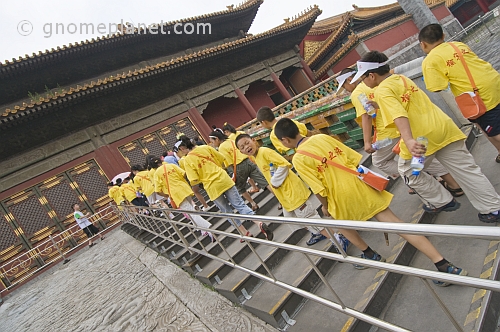 Chinese school-children in yellow teeshirts visit the Forbidden City.