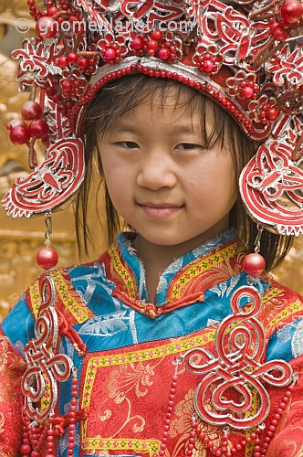 Small Chinese girl poses for photograph in replica Imperial Court clothes.