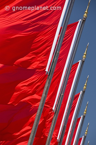 Red Chinese flags for the Peoples Republic of China billowing in the wind of Tiananmen Square.
