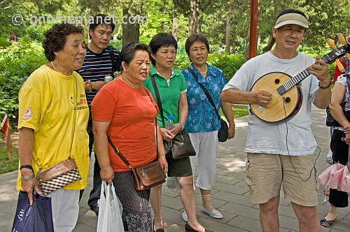 Chinese passers-by stop to join in the Sunday singing at Jingshan Park.