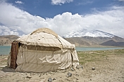 A yurt next to Karakul Lake on the Karakoram Highway, with view of the snow-capped Pamir mountains.