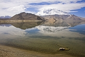 A snow-capped Pamir mountain reflection in Karakul Lake, near the Karakoram Highway between Kashgar and Tashkurgan.