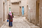 Woman carrying child in the twisting streets of the old city.