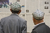 Two Uighur men read the local-language newspapers.
