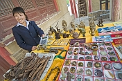 Chinese lady with calculator selling Chinese curios and souvenirs.