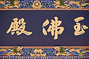 Gold Chinese characters on a black background with painted border, at the Dazhao Lamasery.