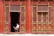 Man reading paper at the Buddhist Temple of Sumeru Happiness and Longevity.