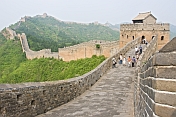 Western and Chinese visitors walk along the Great Wall of China.