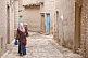Image of Woman carrying child in the twisting streets of the old city.