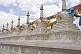 Image of White marble Buddhist stupas draped with prayer flags, at the Dazhao Lamasery.