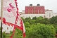 Image of Putuozongcheng Buddhist Temple exterior seen behind white and red flag.