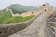 Image of The Great Wall of China crossing forested mountain ranges.
