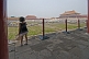 A small Chinese girl watches tourists in the Forbidden City.