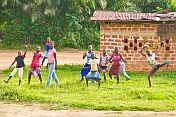 A group of village children dance in excitement when meeting foreign visitors.