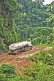 A white fuel tanker struggles to drive along muddy logging roads in the dense jungle.
