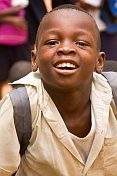 Smiling schoolboy in white shirt enjoys having his photograph taken.