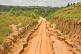 An eroded sandy road leads south from the Angolan border through forest and grassland.