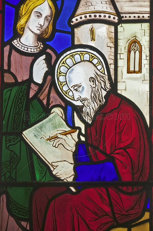 Stained glass of seated Apostle writing in All Saints Church at Thirkleby.