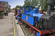 A steam train at Kirklees Light Railway at Clayton West pulls up at the platform.