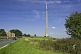 Image of The 330m 1080 feet high Emley Moor TV transmission tower dominates nearby road and houses.
