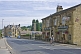 Cylist passes The Postcard public house on the Huddersfield Road A6024.